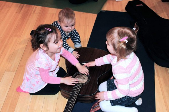 Kids playing with a guitar at Musik Kinderlein | City Kinder